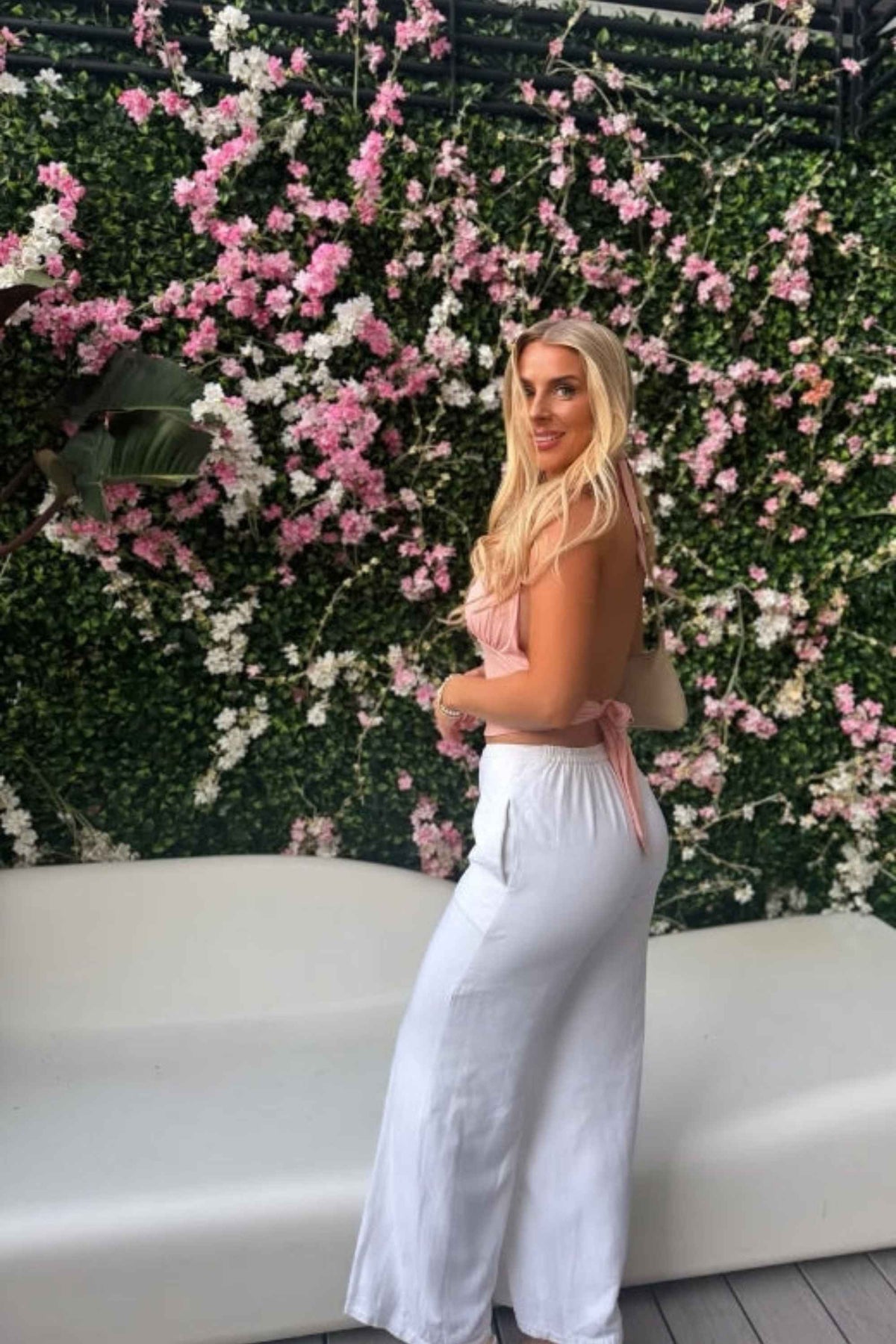 Woman wearing a figure flattering Aby Halter Top - Pink Peach Fuzz BODYCON COLLECTION Pty Ltd
