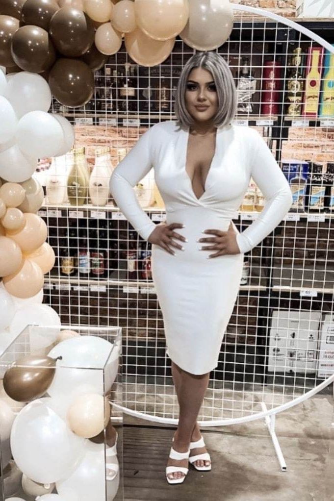 Woman wearing a figure flattering Blaire Long Sleeve Bandage Dress - Pearl White BODYCON COLLECTION