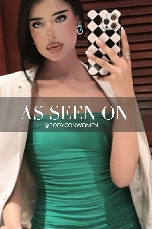 Woman wearing a figure flattering Cassie Bodycon Wrap Mini Dress - Emerald Green BODYCON COLLECTION