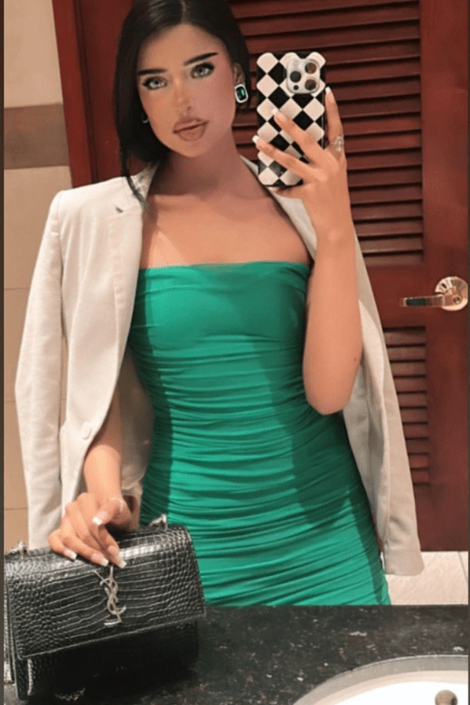 Woman wearing a figure flattering Cassie Bodycon Wrap Mini Dress - Emerald Green BODYCON COLLECTION