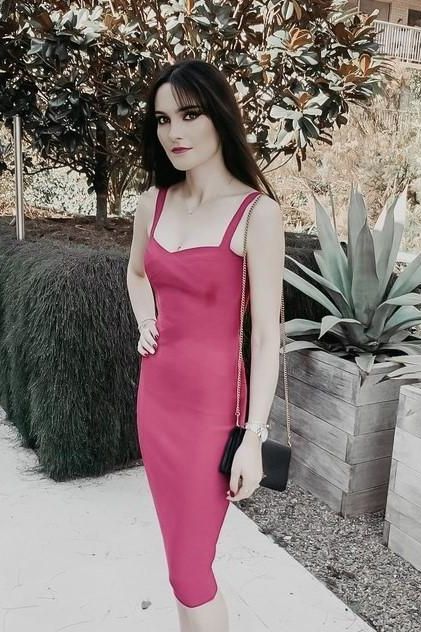 Woman wearing a figure flattering Heidi Bandage Midi Dress - Magenta Pink Bodycon Collection