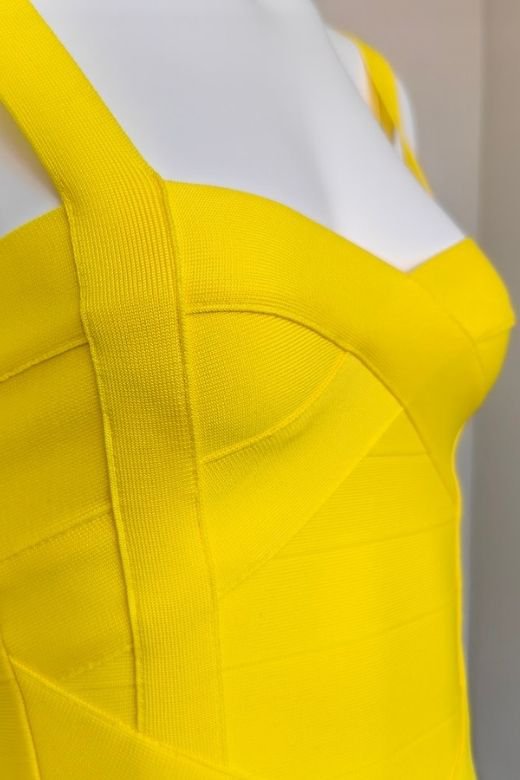 Woman wearing a figure flattering Heidi Bandage Midi Dress - Sun Yellow Bodycon Collection
