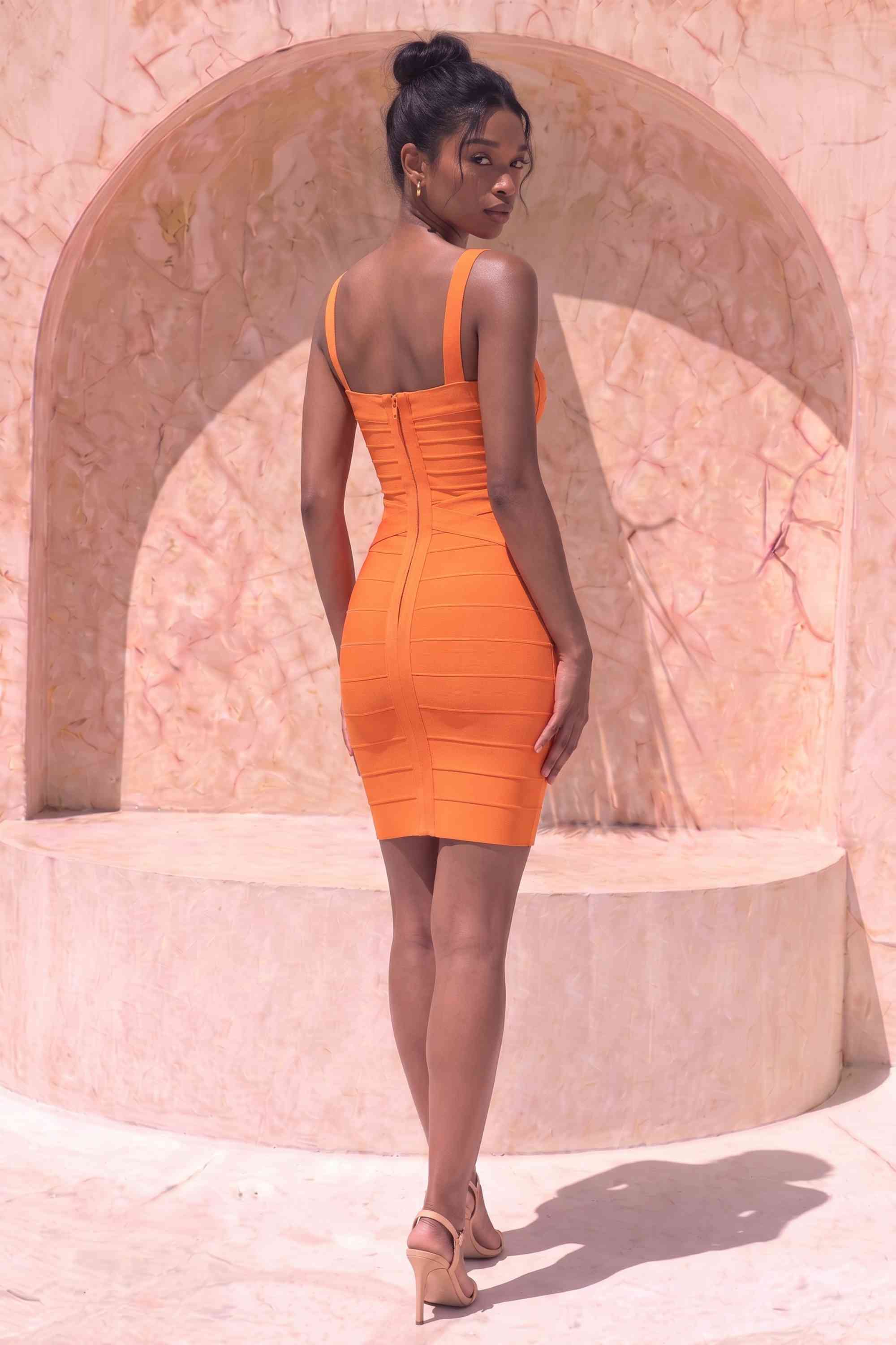 Woman wearing a figure flattering Heidi Bandage Mini Dress - Apricot Orange Bodycon Collection