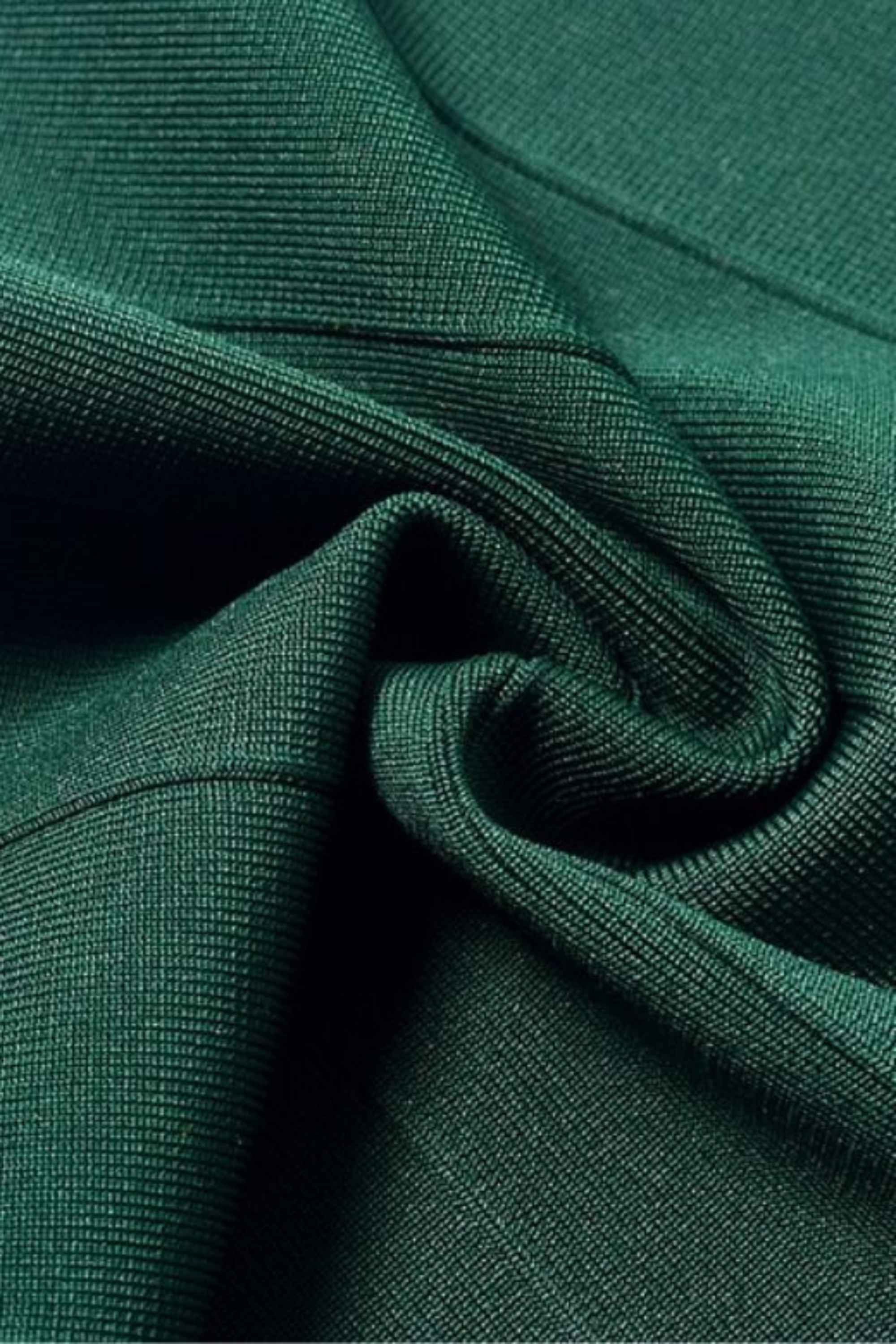 Woman wearing a figure flattering Josie Bandage V Neck Mini Dress - Emerald Green BODYCON COLLECTION
