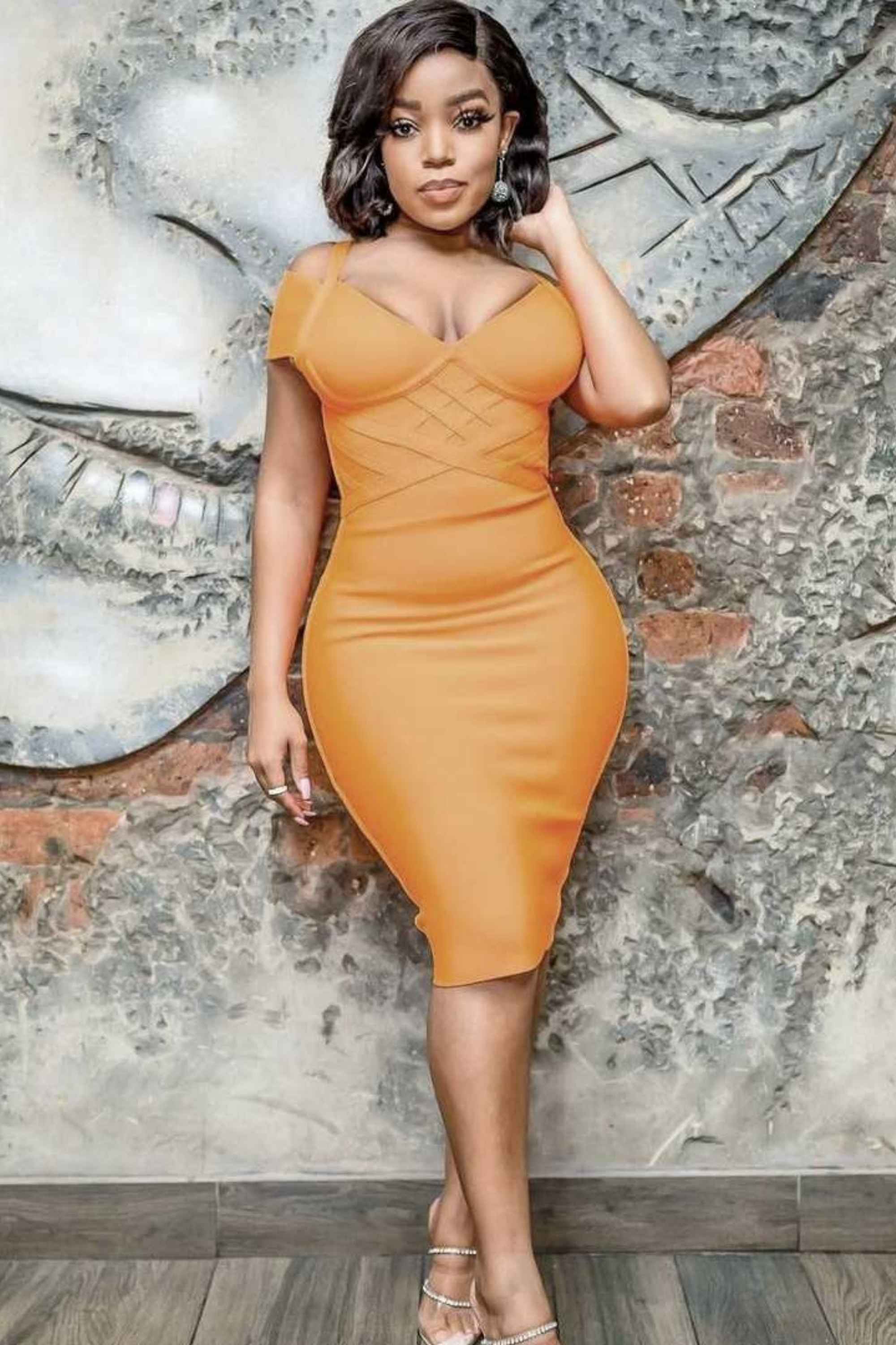 Woman wearing a figure flattering Leo Bandage Dress - Apricot Orange Bodycon Collection