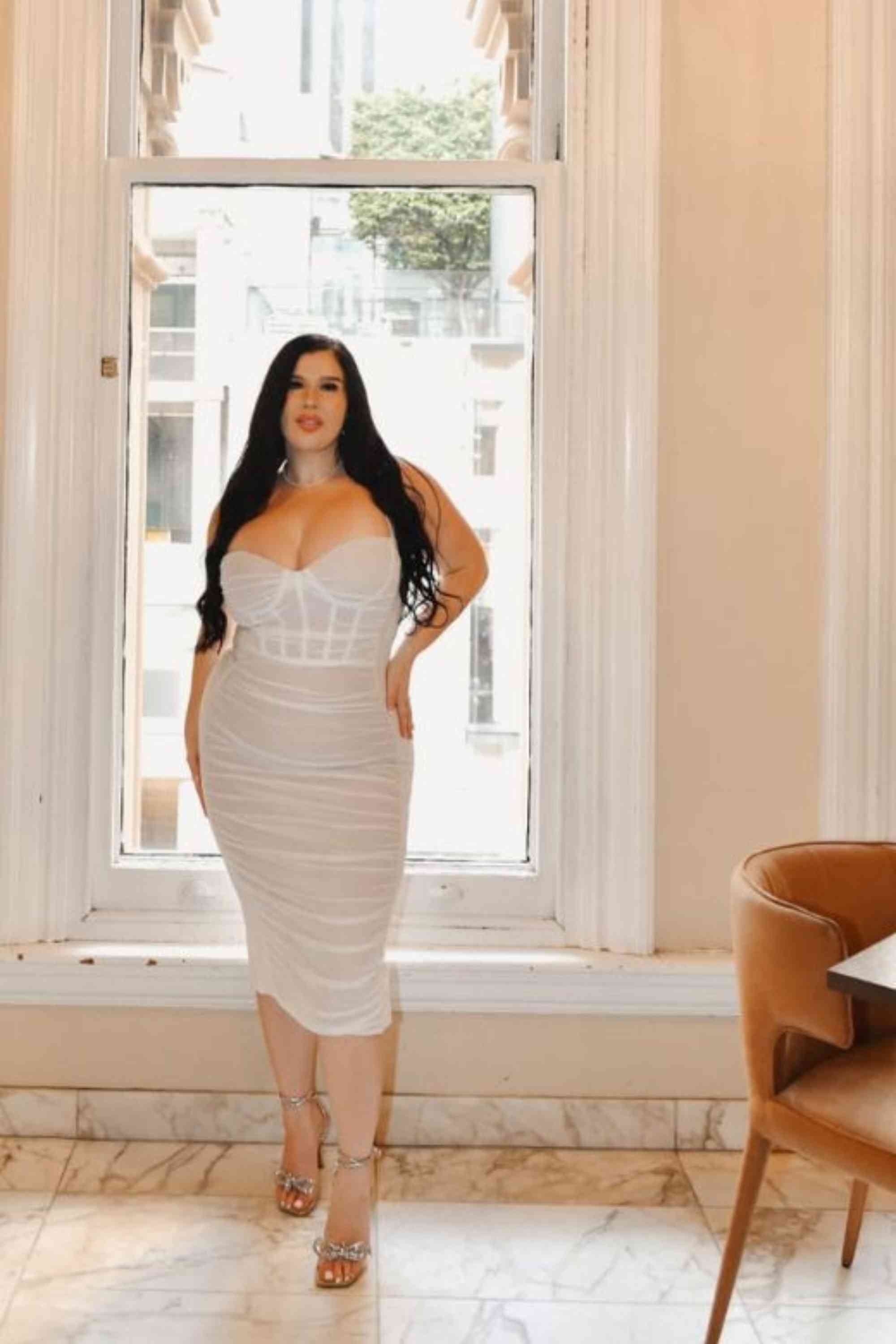 Woman wearing a figure flattering Marilyn Bodycon Wrap Midi Dress - Classic Black BODYCON COLLECTION