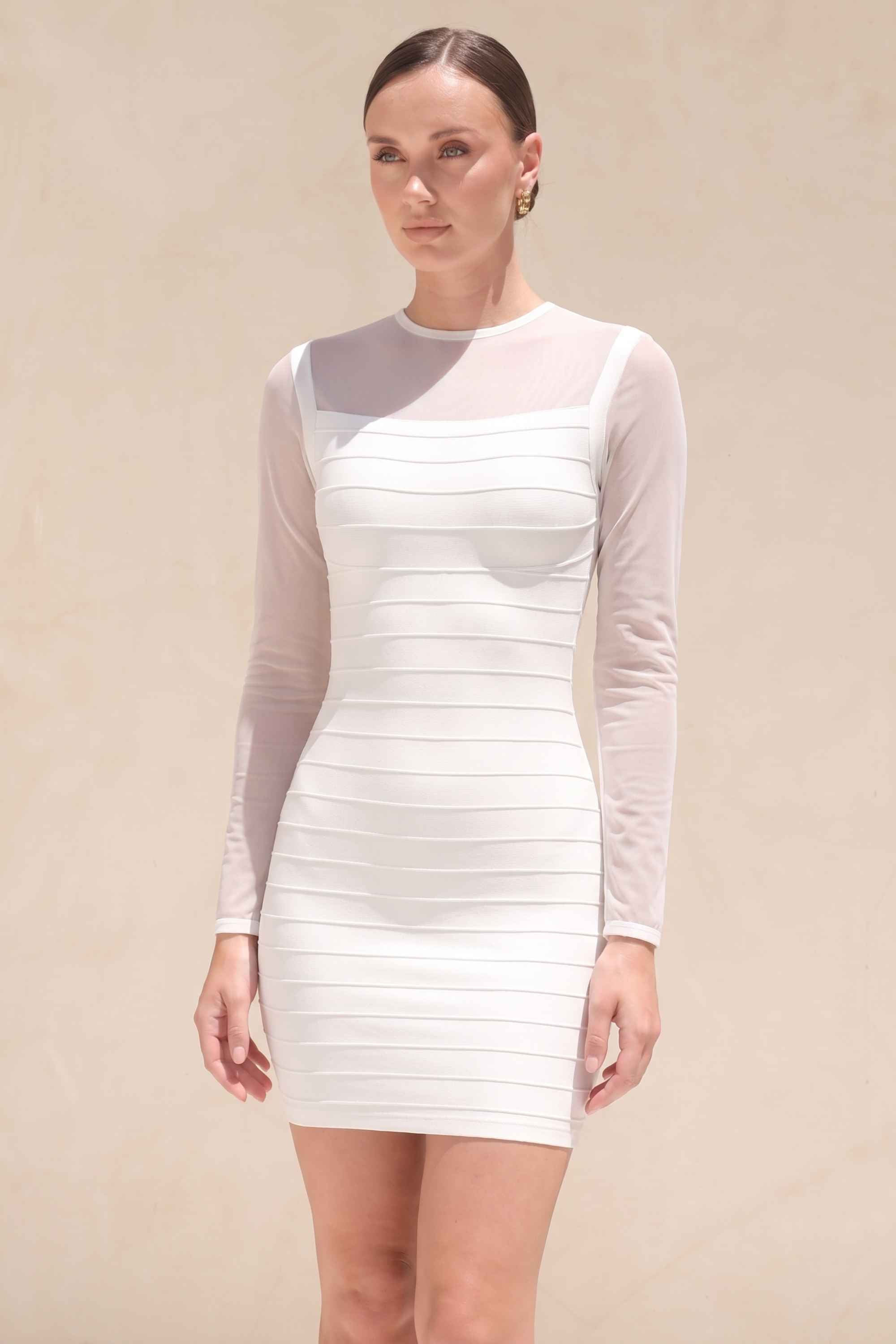 Woman wearing a figure flattering Robin Long Sleeve Bandage Mini Dress - White Pearl BODYCON COLLECTION Pty Ltd