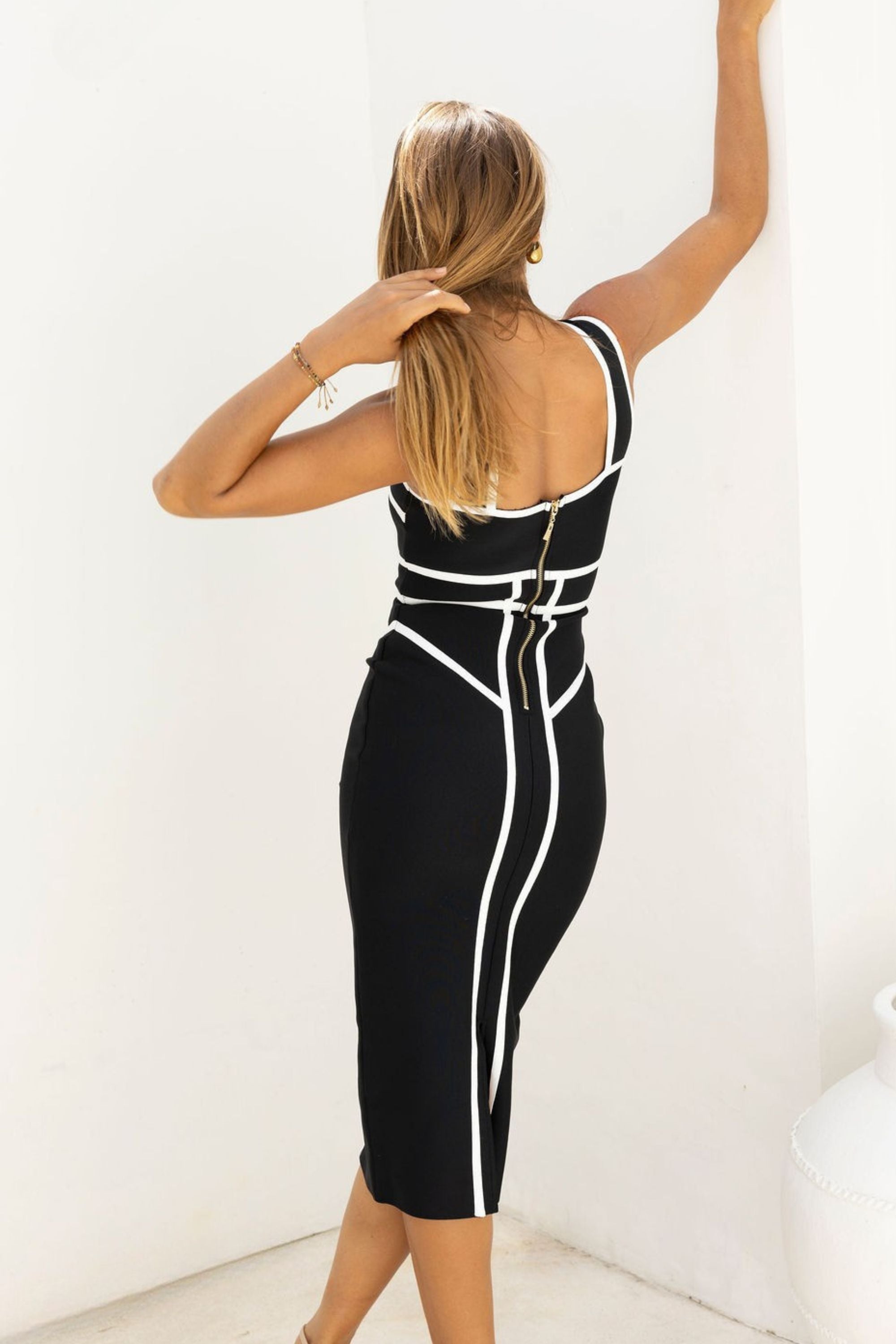 Woman wearing a figure flattering Suki Bandage Midi Dress - Classic Black BODYCON COLLECTION